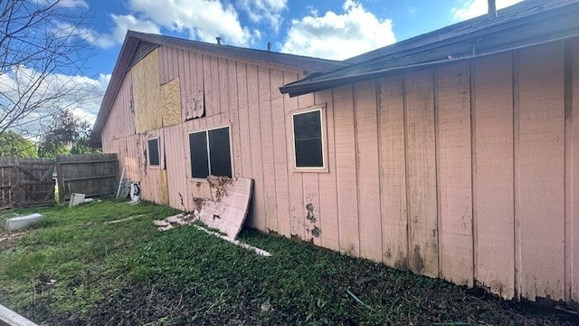 view of property exterior with fence and a lawn