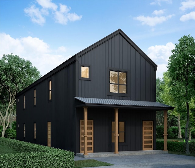 view of front facade featuring a standing seam roof, board and batten siding, an outdoor structure, and an exterior structure