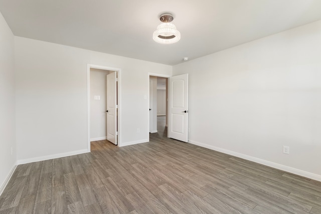 unfurnished room featuring baseboards and wood finished floors