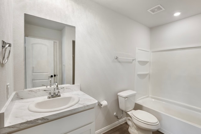 bathroom featuring visible vents, toilet, tub / shower combination, vanity, and baseboards