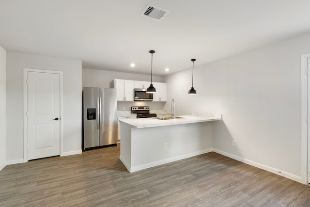 kitchen with stainless steel appliances, a peninsula, visible vents, white cabinetry, and light countertops