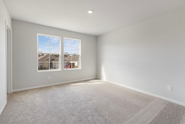 unfurnished room featuring carpet flooring and baseboards