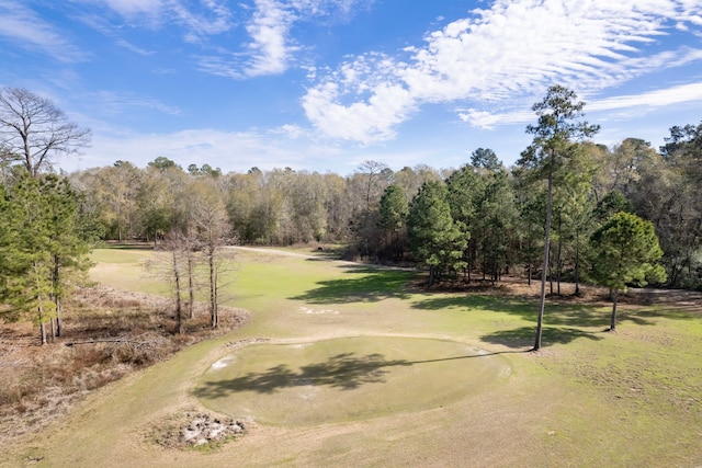 surrounding community with view of golf course and a yard