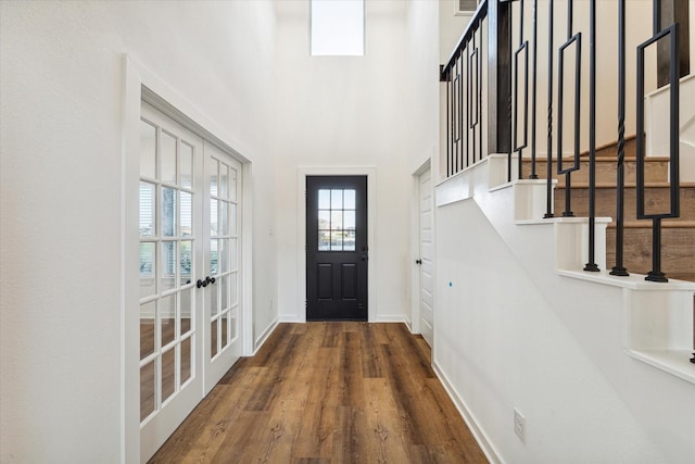 entryway featuring french doors, stairway, baseboards, and wood finished floors