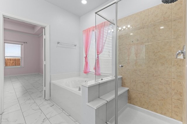 bathroom featuring marble finish floor, a shower stall, and a garden tub