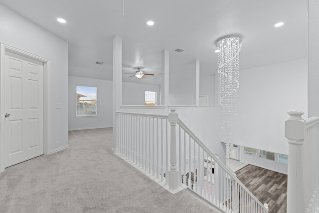 corridor with recessed lighting, a chandelier, carpet flooring, and an upstairs landing