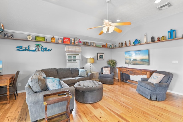 living room with ceiling fan, wood finished floors, visible vents, baseboards, and vaulted ceiling