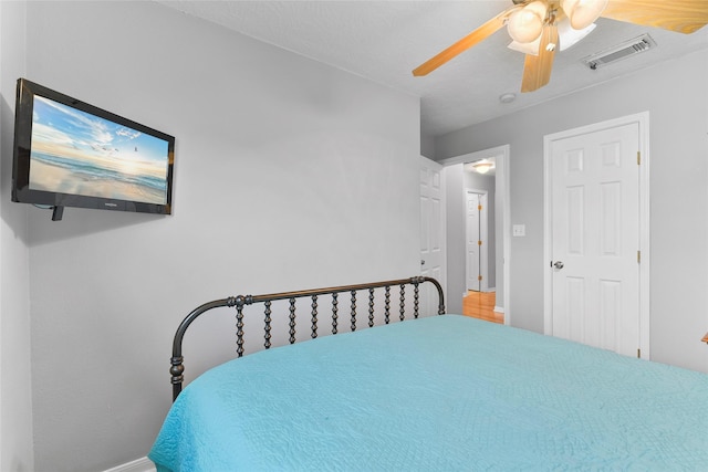 bedroom with ceiling fan, visible vents, and baseboards