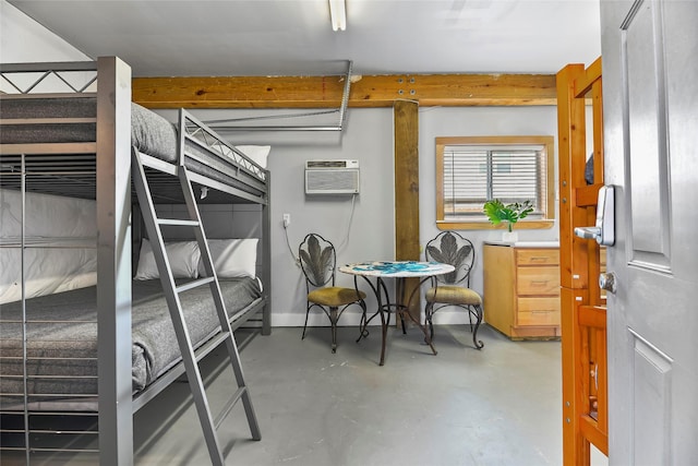 bedroom with finished concrete flooring, a wall mounted air conditioner, and baseboards