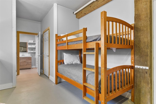 bedroom with finished concrete flooring and baseboards