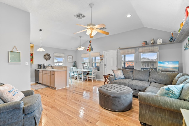 living room with baseboards, visible vents, ceiling fan, vaulted ceiling, and light wood-type flooring