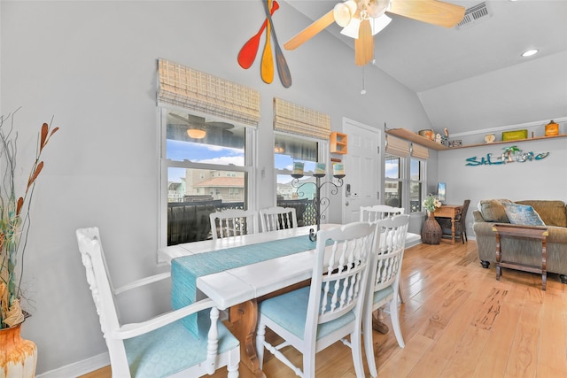 dining area with baseboards, visible vents, a ceiling fan, vaulted ceiling, and light wood-style floors