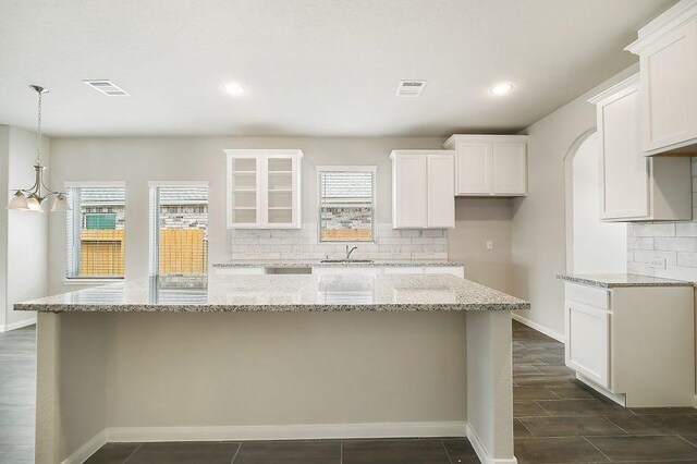 kitchen with white cabinetry and light stone counters