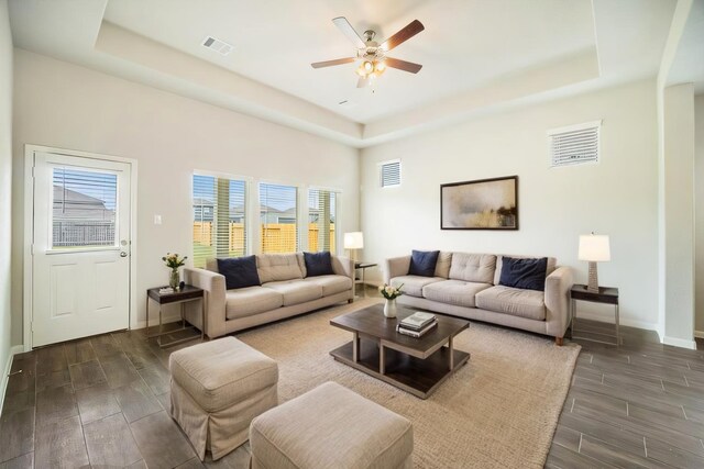 living area featuring visible vents, a raised ceiling, and wood finish floors