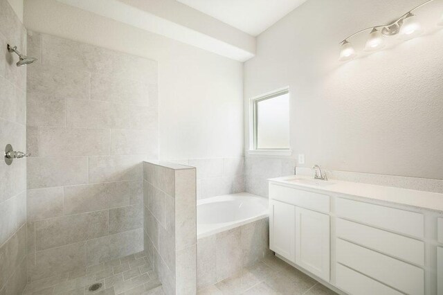 full bathroom featuring a garden tub, vanity, tiled shower, and tile patterned floors