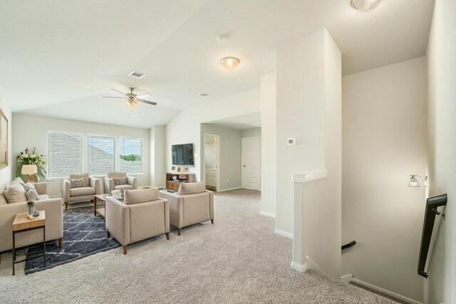 living area with lofted ceiling, visible vents, light carpet, ceiling fan, and baseboards
