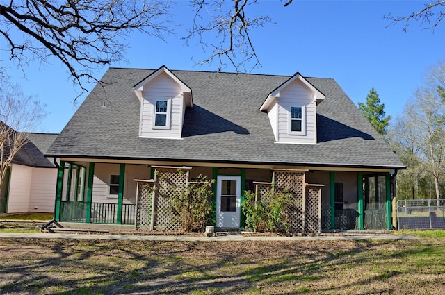 view of front of property featuring a porch, roof with shingles, and a front yard