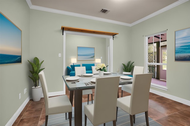 dining room featuring visible vents, crown molding, dark tile patterned floors, and baseboards