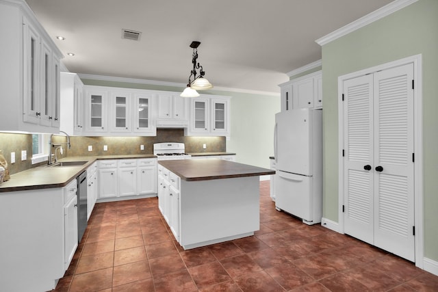 kitchen with dark countertops, visible vents, freestanding refrigerator, white cabinets, and a kitchen island