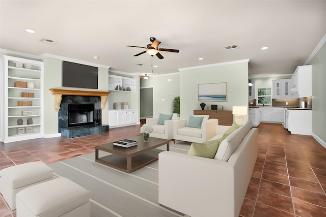 tiled living room featuring recessed lighting, visible vents, and a high end fireplace