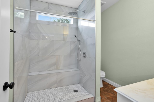 bathroom featuring baseboards, a shower stall, toilet, and tile patterned floors