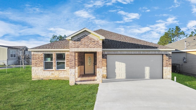 single story home with a garage, concrete driveway, roof with shingles, a front yard, and brick siding