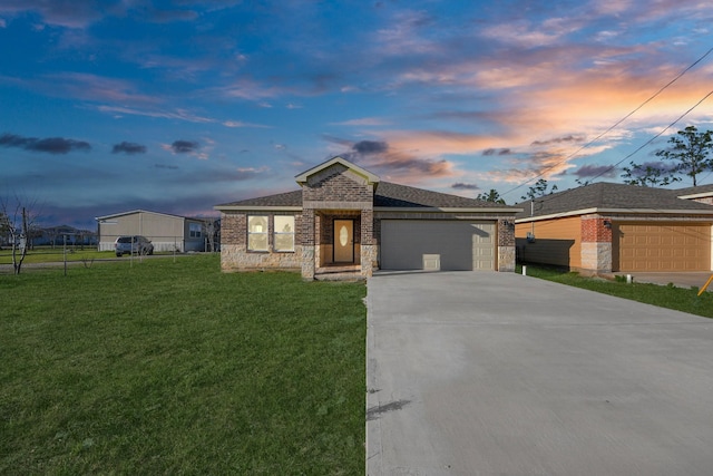 view of front facade featuring brick siding, concrete driveway, a garage, stone siding, and a front lawn