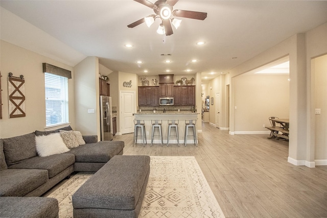 living room with light wood-style floors, ceiling fan, baseboards, and recessed lighting