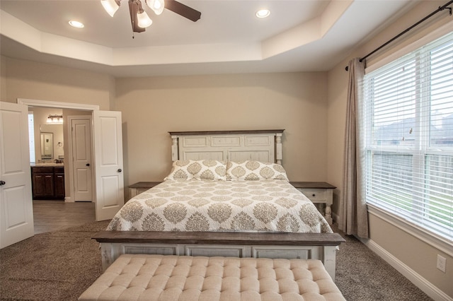 bedroom with baseboards, a raised ceiling, ceiling fan, dark carpet, and recessed lighting