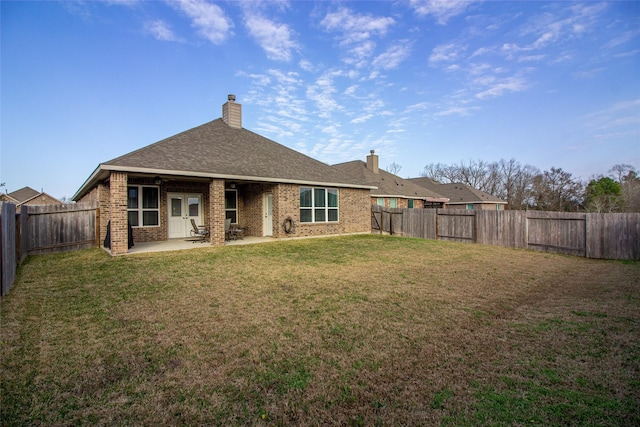 rear view of property with a patio area, a fenced backyard, a lawn, and brick siding