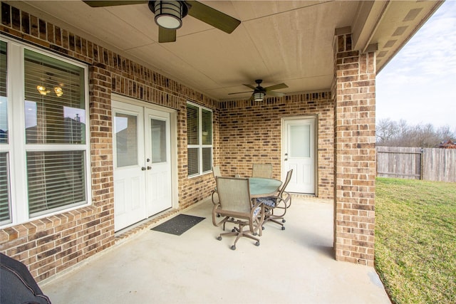 view of patio with fence, outdoor dining area, a ceiling fan, and french doors