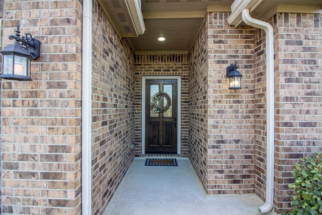 view of exterior entry featuring brick siding