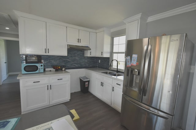 kitchen with under cabinet range hood, a sink, ornamental molding, stainless steel refrigerator with ice dispenser, and tasteful backsplash