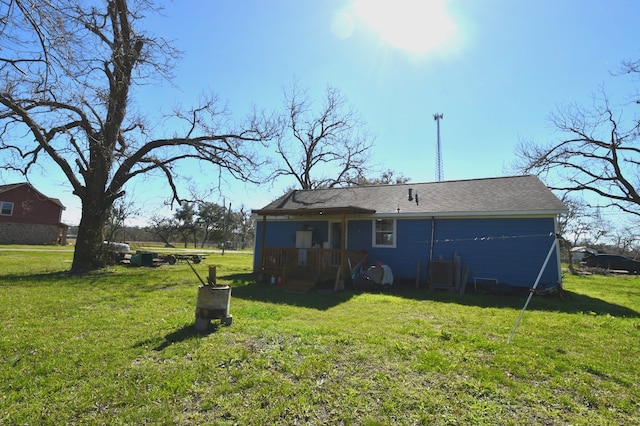 back of house featuring central AC and a yard