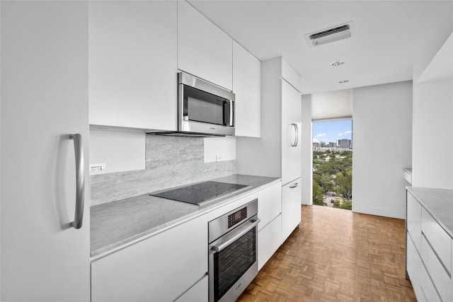 kitchen featuring visible vents, appliances with stainless steel finishes, white cabinets, and light countertops