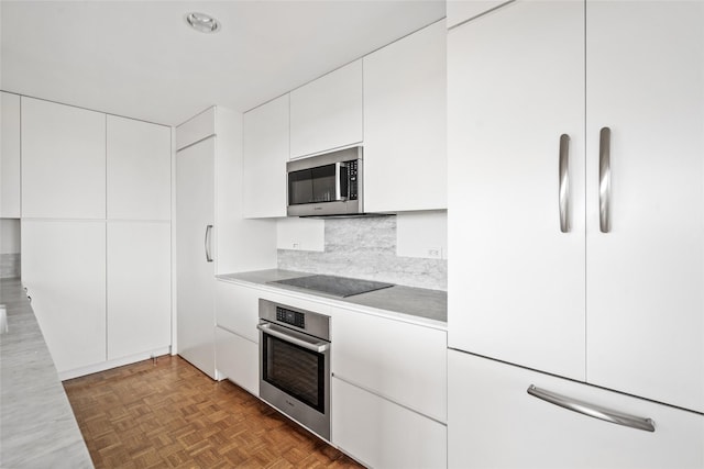 kitchen featuring modern cabinets, white cabinetry, stainless steel appliances, and light countertops