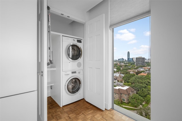 laundry area featuring a view of city, stacked washer and clothes dryer, and laundry area