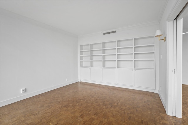 spare room with baseboards, visible vents, and crown molding