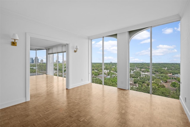 unfurnished room featuring ornamental molding, a view of city, expansive windows, and baseboards