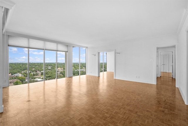 unfurnished living room with expansive windows, crown molding, and baseboards