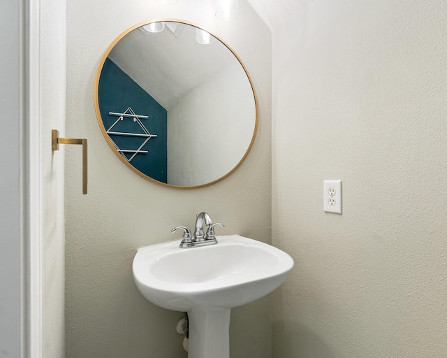 bathroom with a textured wall and a sink