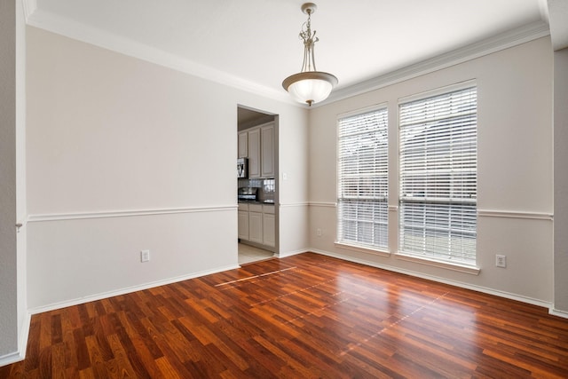 unfurnished room with dark wood-style flooring, crown molding, and baseboards