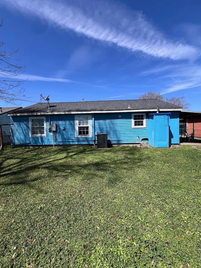 back of house with central AC and a lawn