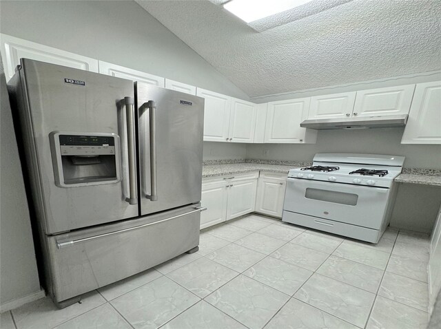 kitchen with white gas range, stainless steel fridge, white cabinetry, and under cabinet range hood