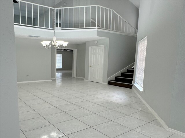 interior space with stairway, a towering ceiling, and baseboards