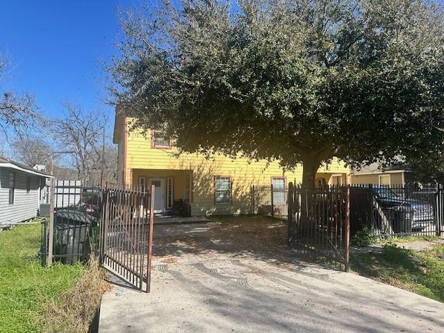 obstructed view of property featuring a fenced front yard and a gate