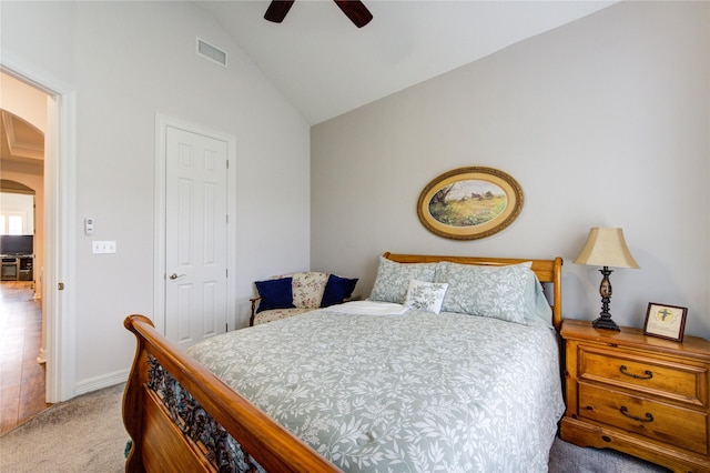 bedroom featuring arched walkways, lofted ceiling, visible vents, light carpet, and ceiling fan