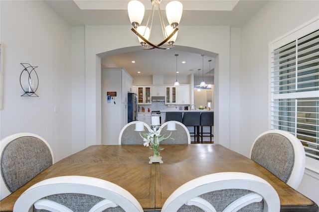 dining room featuring arched walkways, a notable chandelier, and recessed lighting