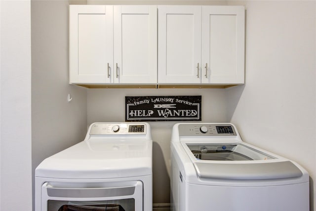 washroom with separate washer and dryer and cabinet space