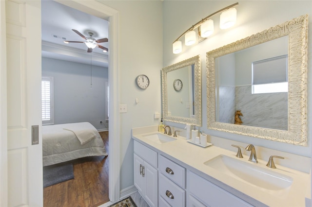 bathroom with double vanity, wood finished floors, a sink, and ensuite bathroom